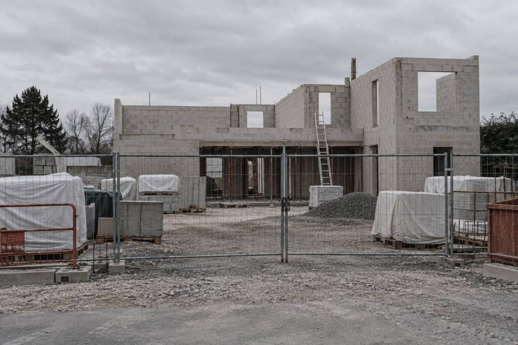 Chantier de construction a l'arret avec ossature en parpaings et materiaux baches